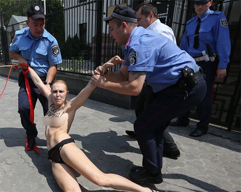 Активистка FEMEN показала голую грудь перед посольством России - фото